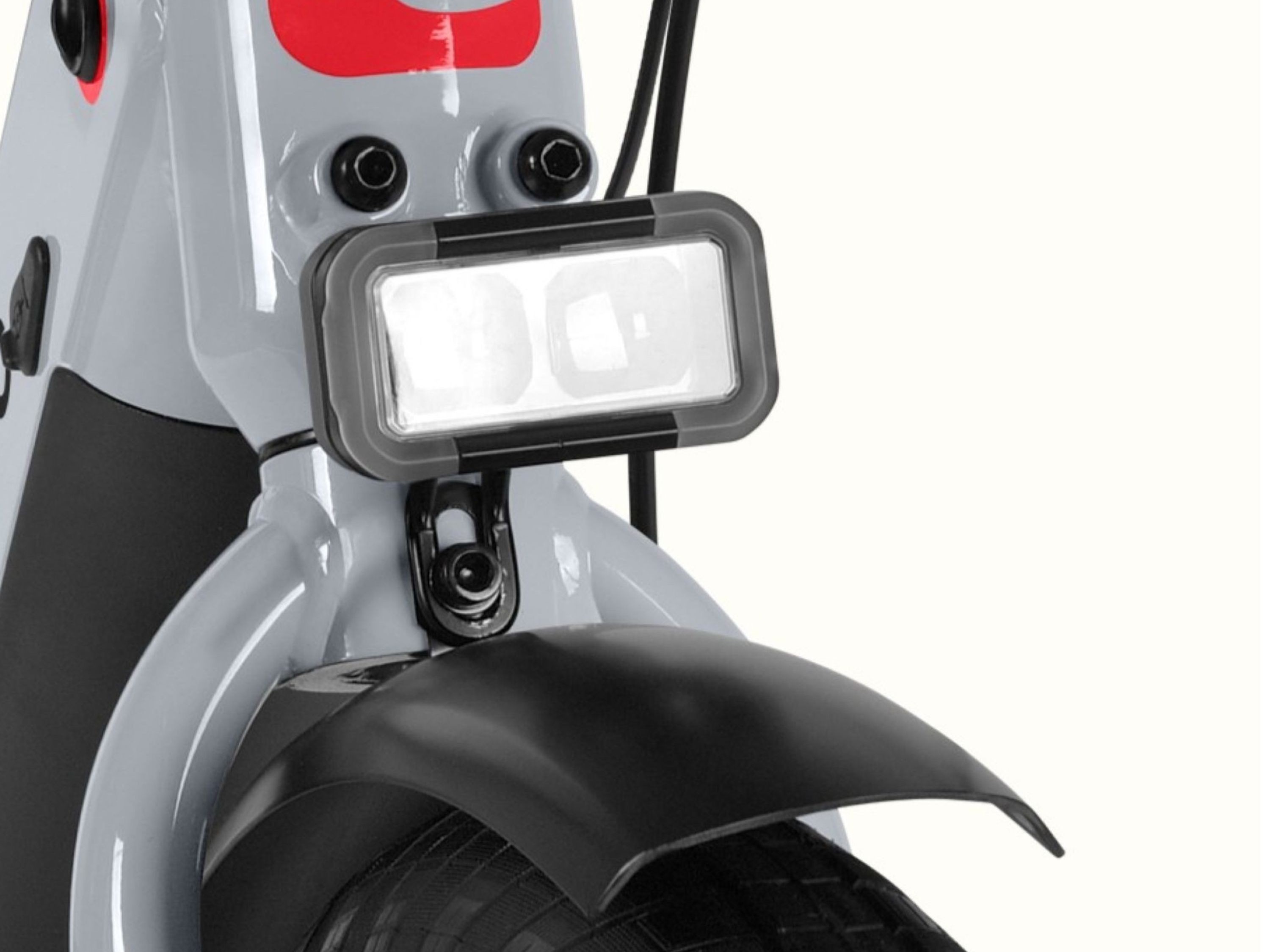 A close-up of the headlight and front fender on the gray Abbot Rev 2 Commuter Electric Bike.