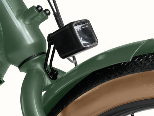 A close-up of the headlight on the Beaumont Rev+ EBike with view of the front fender over the black tire with brown sidewall.