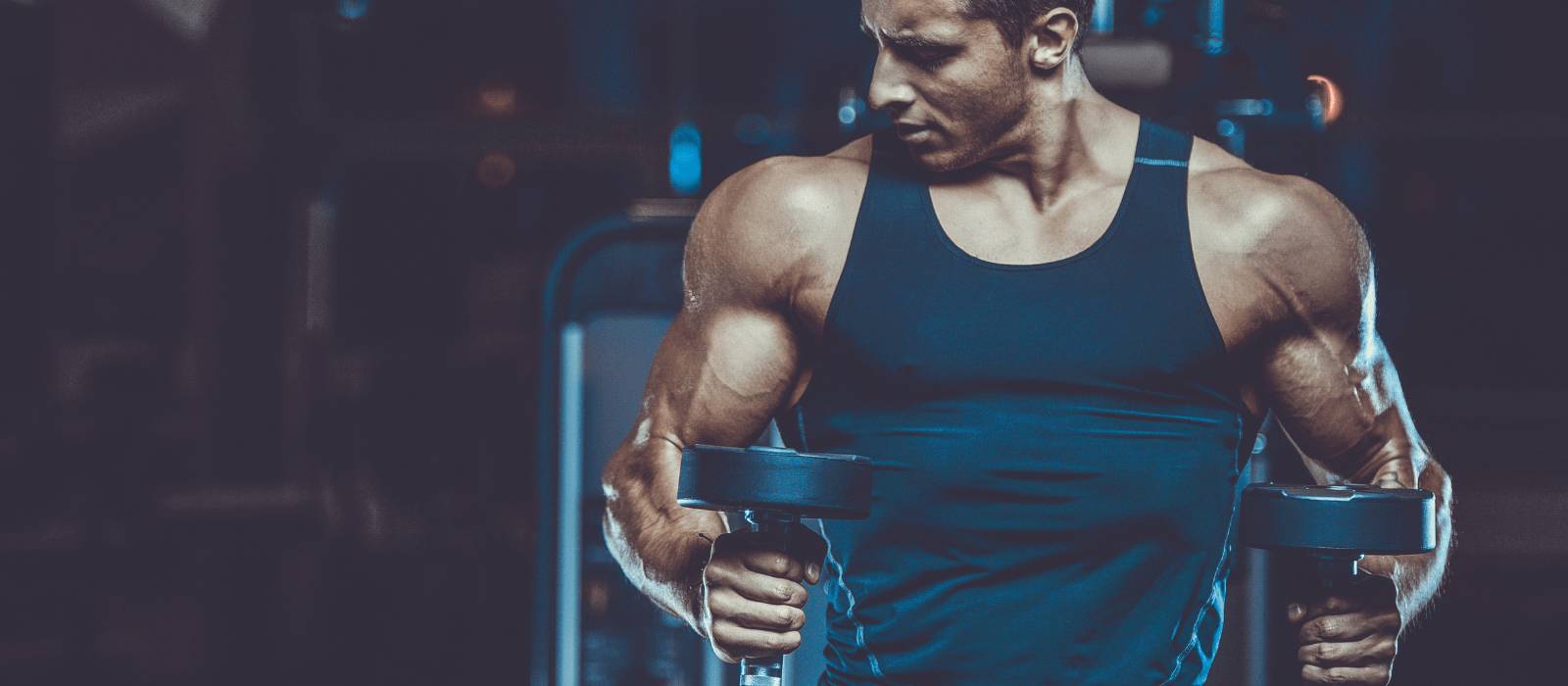 Man in the gym lifting weights and getting more muscle growth with U Perform's Active Whey & Collagen