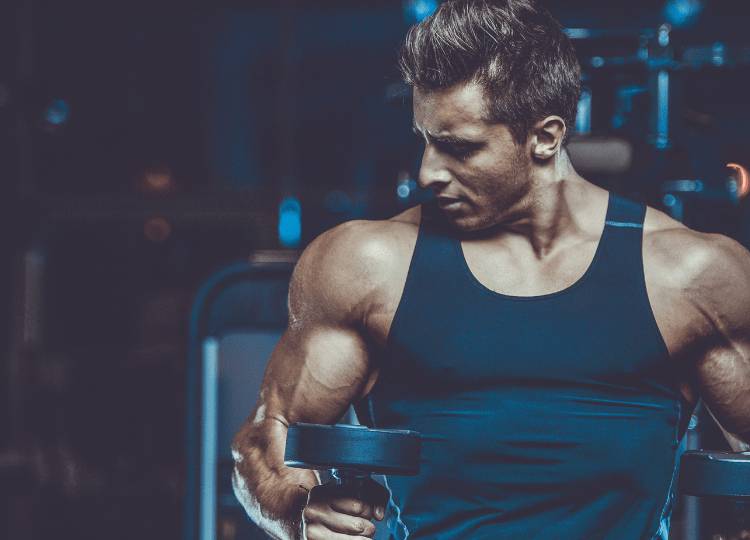 Man in the gym lifting weights and getting more muscle growth with U Perform's Active Whey & Collagen