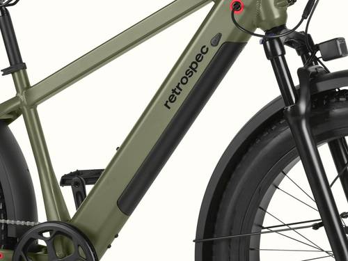 Close-up of the Koa Rev 3 Fat Tire Electric Bike's frame with the integrated battery, featuring a green color and the "retrospec" logo, alongside a black suspension fork and tires.