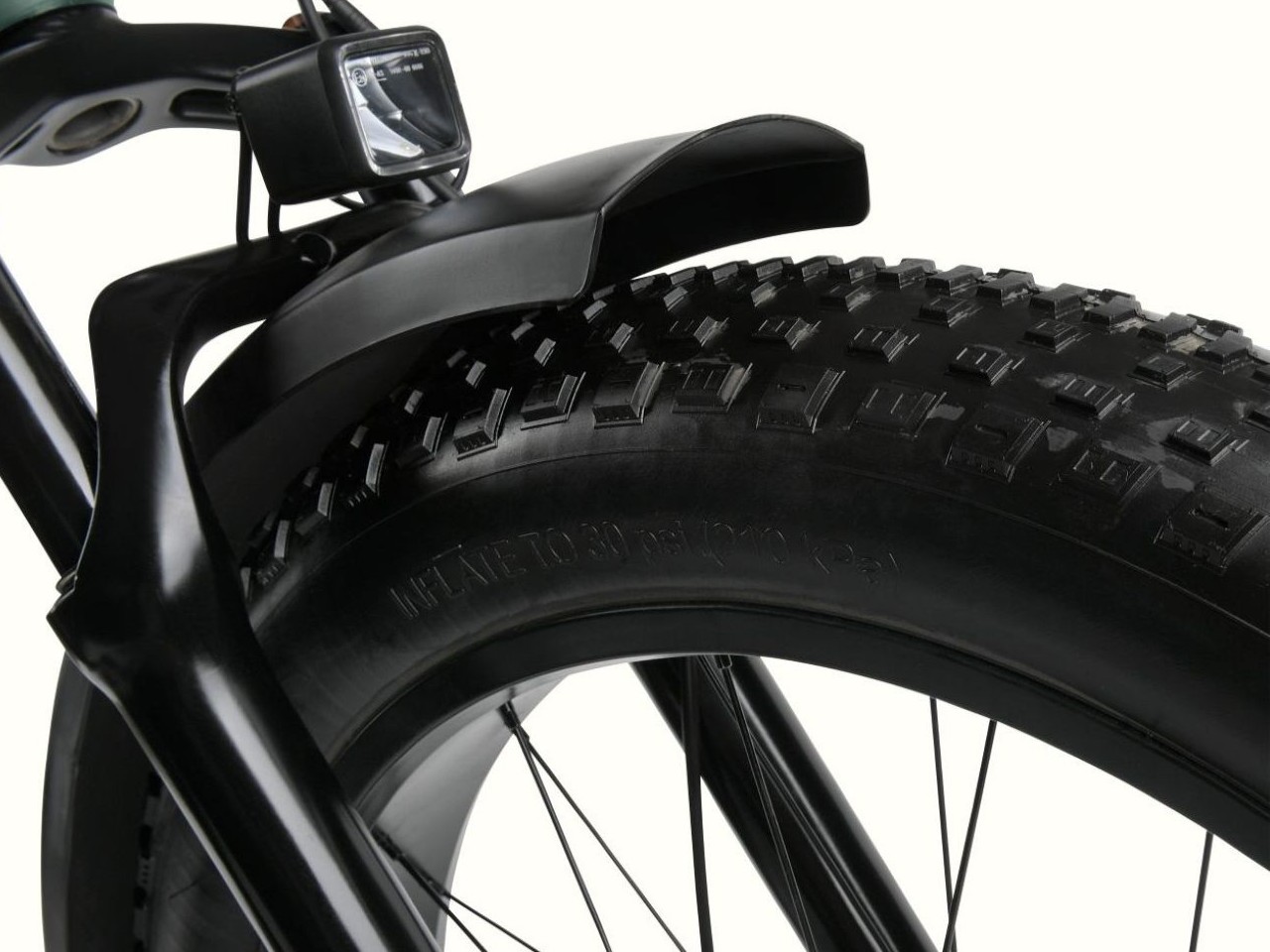 A close up of the Koa Rev 3 Fat Tire Electric Bike's black tire with heavy duty tread and black fender.