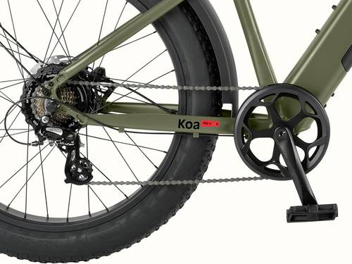 Close-up of a green Koa Rev 3 Fat Tire Electric  Bicycle's drivetrain, featuring a thick tire, chain, and "Koa REV" branding on the frame.
