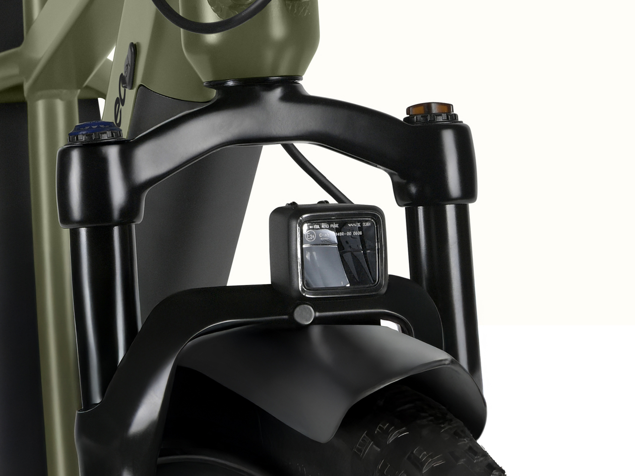 Close-up of the ebike's front fork with a mounted LED headlight, showcasing cables and a sleek black design against a light background.