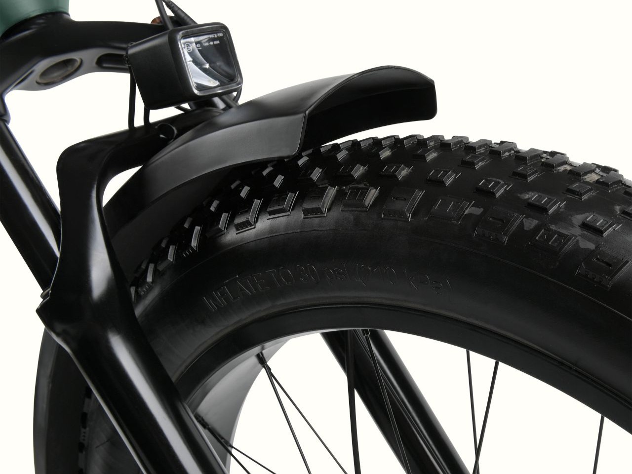 A close up of the Koa Rev 3 Fat Tire Electric Bike's black tire with heavy duty tread and black fender.
