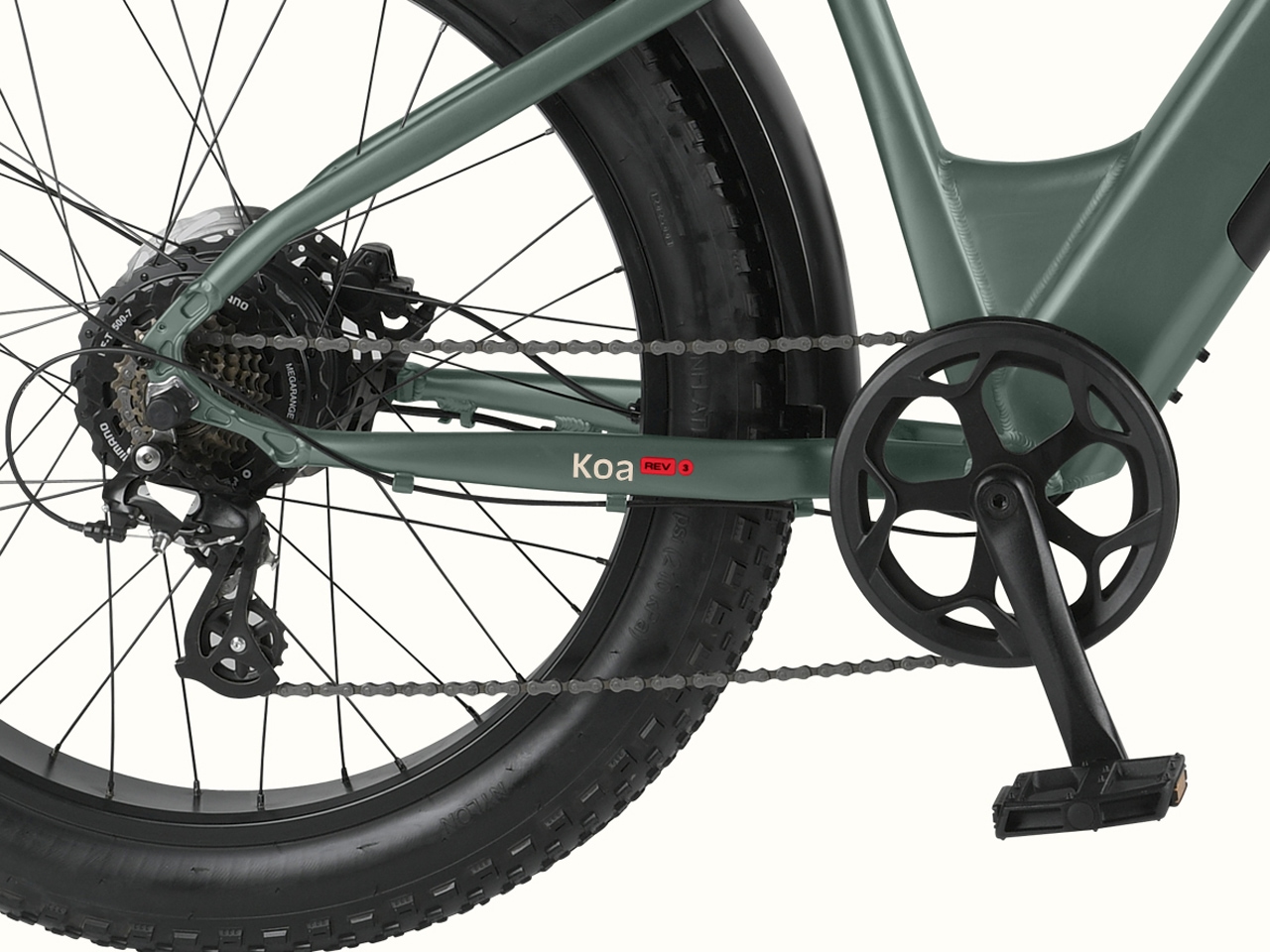 Close-up of a green Koa Rev 3 Fat Tire Electric  Bicycle's drivetrain, featuring a thick tire, chain, and 