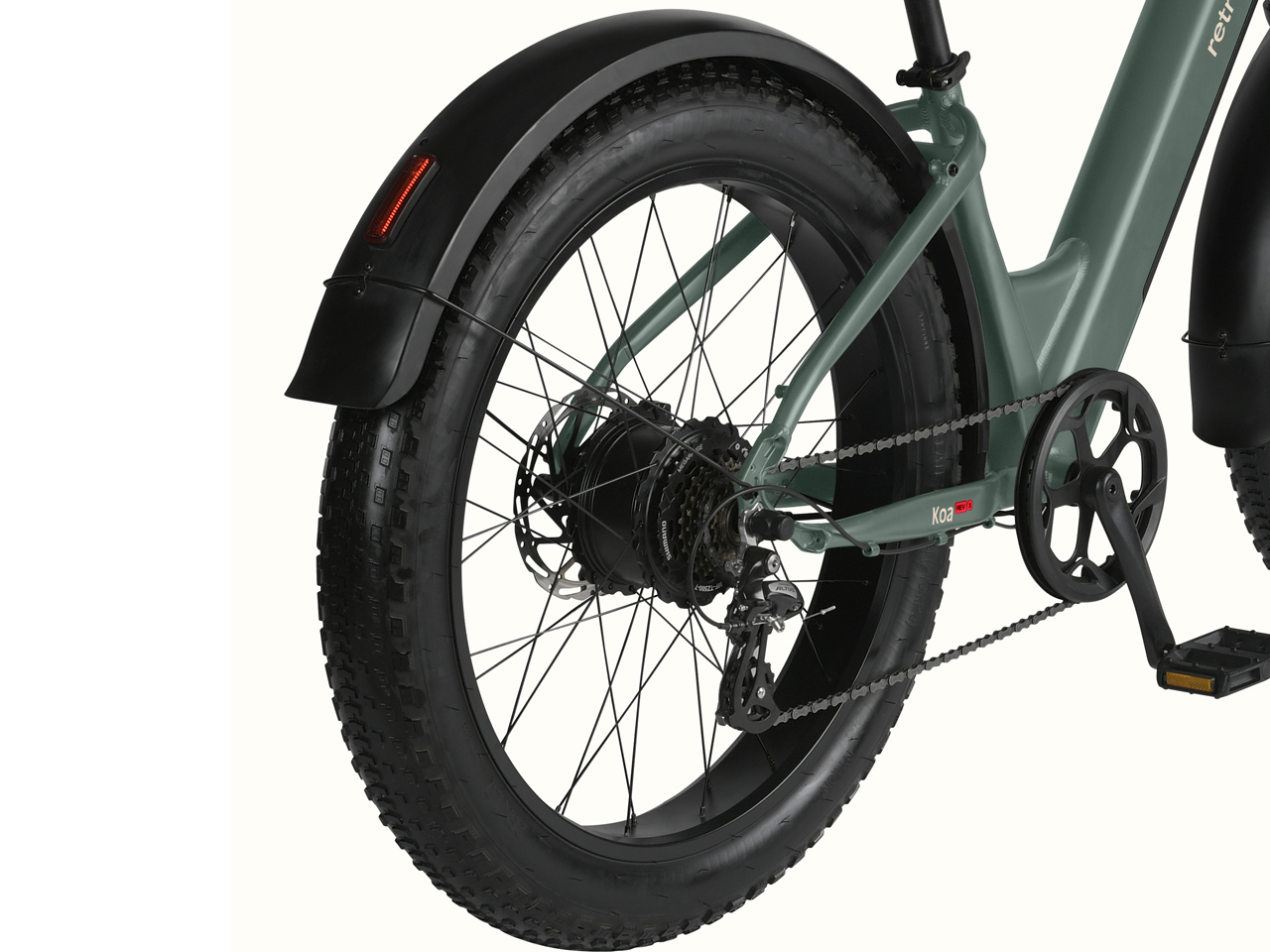Close-up of a green Koa Rev 3 Fat Tire Electric Bike's rear wheel, featuring a robust fat tire, chain, derailleur, and fender.