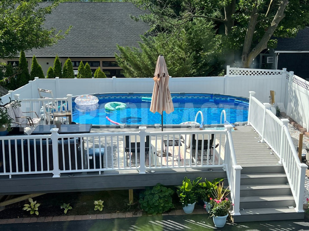 Oval saltwater swimming pool with partial deck and lounge chairs
