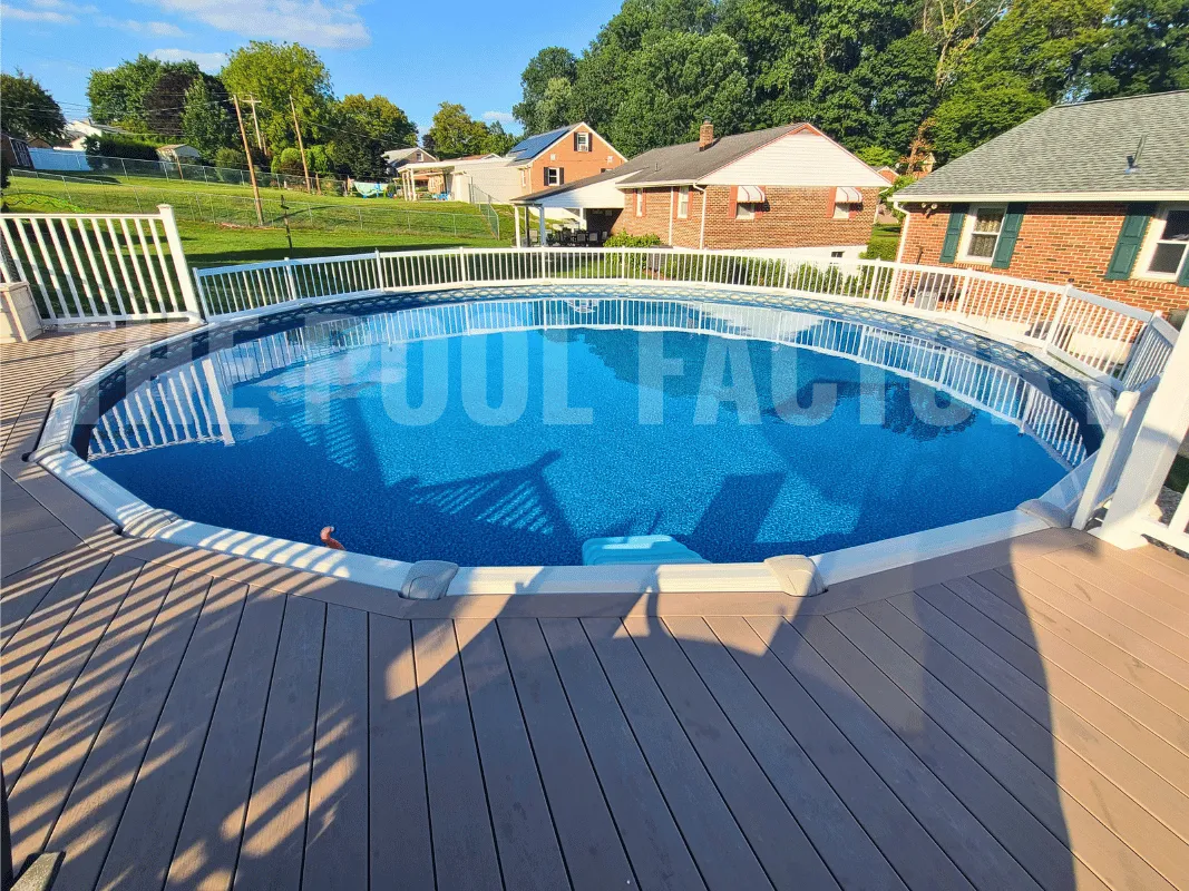 Saltwater 5000 Lazer round pool beside a spacious deck and manicured backyard lawn.