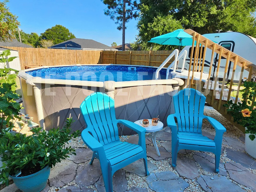 Above ground round saltwater pool in a lush backyard with stone patio and vibrant flowers.