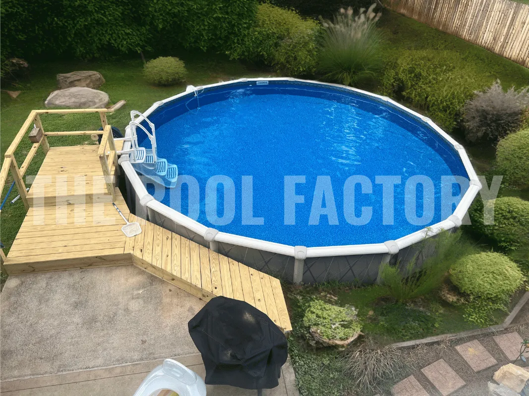 Saltwater 5000 Lazer round pool with wooden deck surrounded by colorful flower beds and green grass.