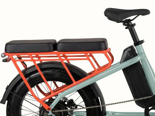 Close-up of the retrospec Roo Rev XL electric cargo bike showing the black passenger seat pad installed on the orange rear rack with wheel guard set and integrated battery.