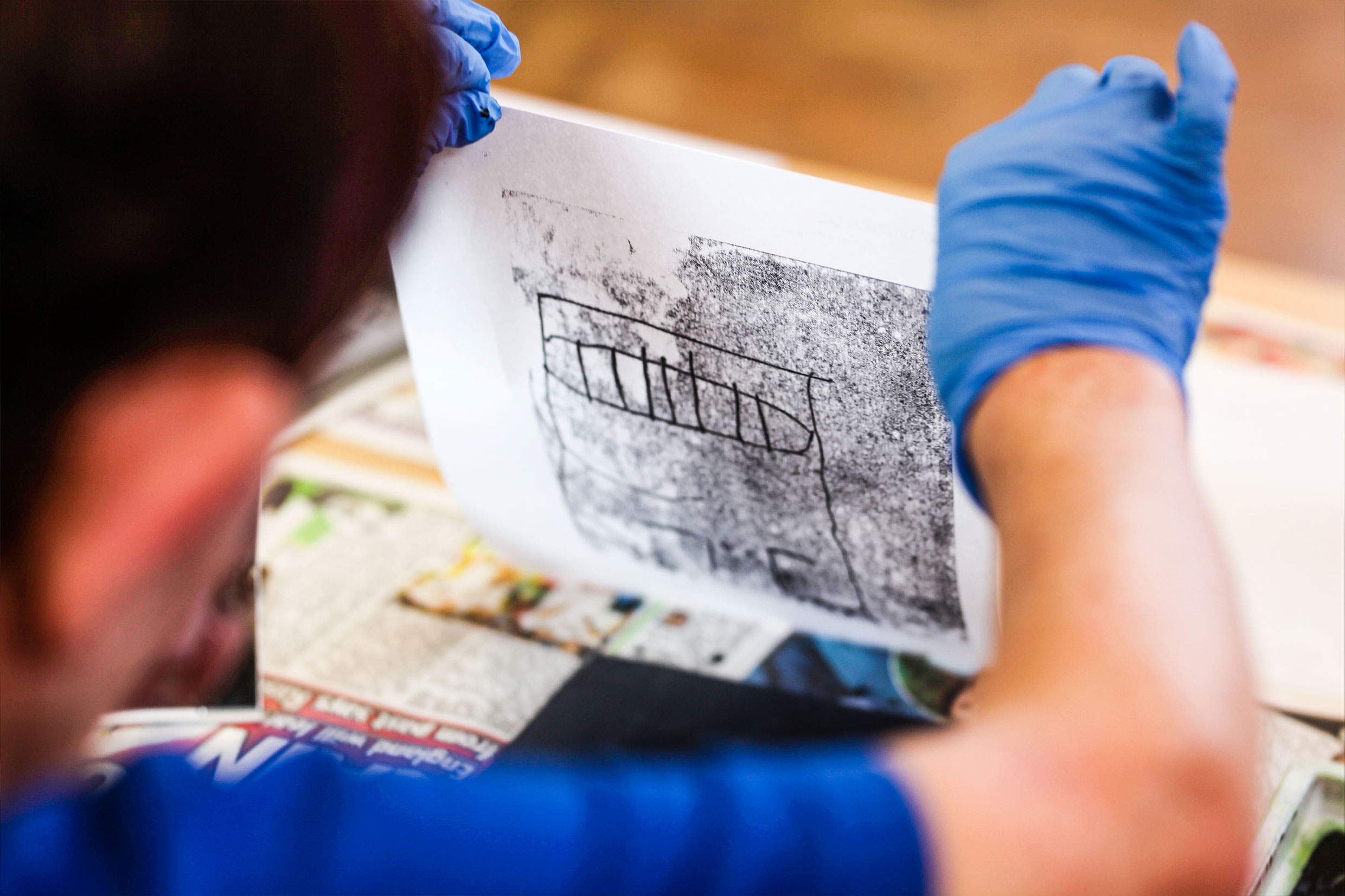 Image of a person revealing a monoprint artwork 
