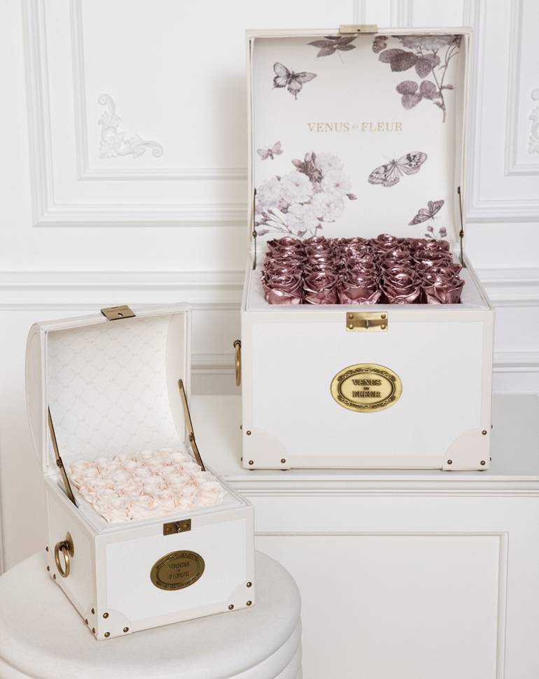 two trunk inspired boxes with white roses and another with purple