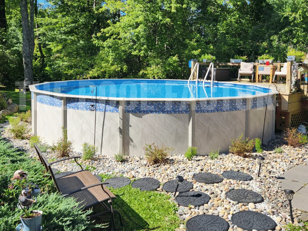 Backyard above ground pool surrounded by partial deck with a spacious lounging area