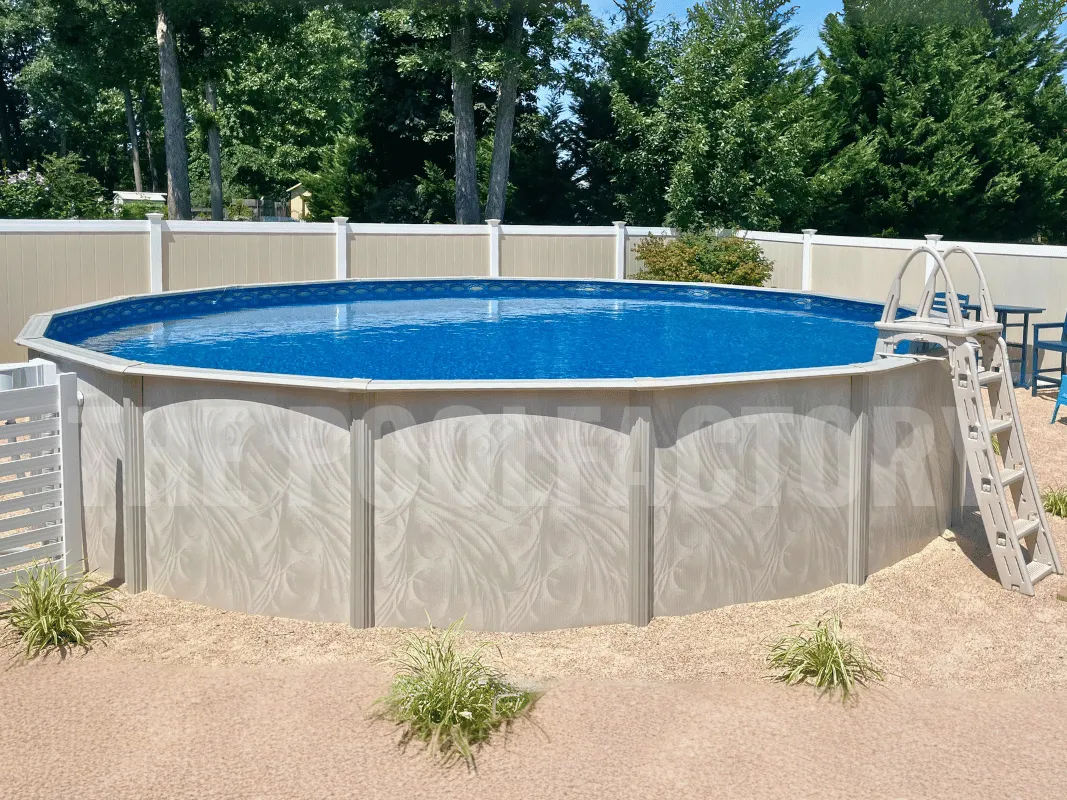 Round above ground pool surrounded by sand and plants with a-frame ladder
