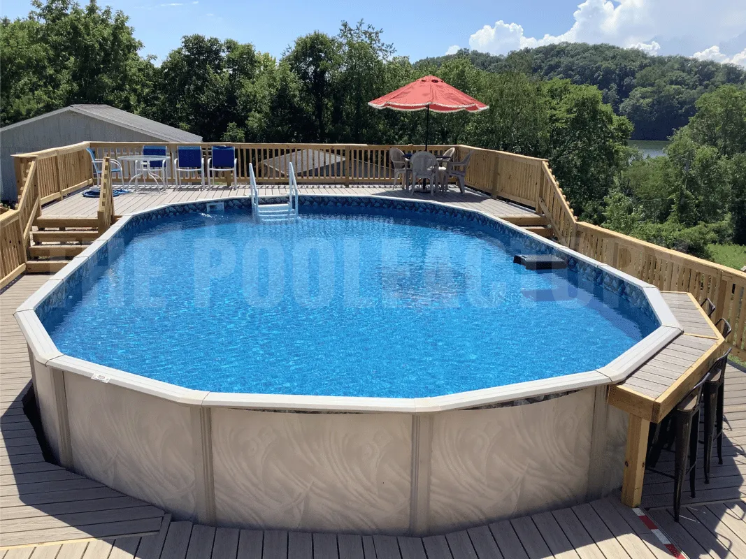 Oval above ground pool with complete deck, umbrellas, and spacious seating area