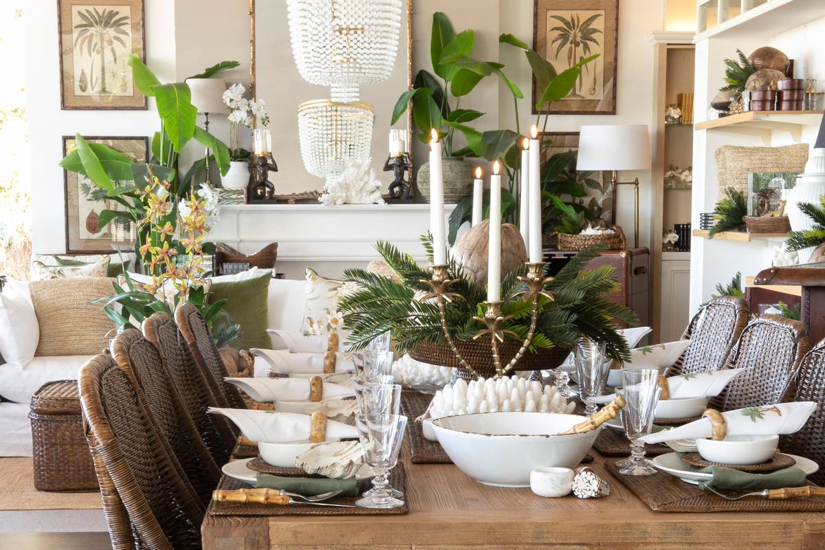 A tropical dining table with dark rattan chairs, bamboo cutlery and hand-painted ceramic plates at our flagship Collaroy store.
