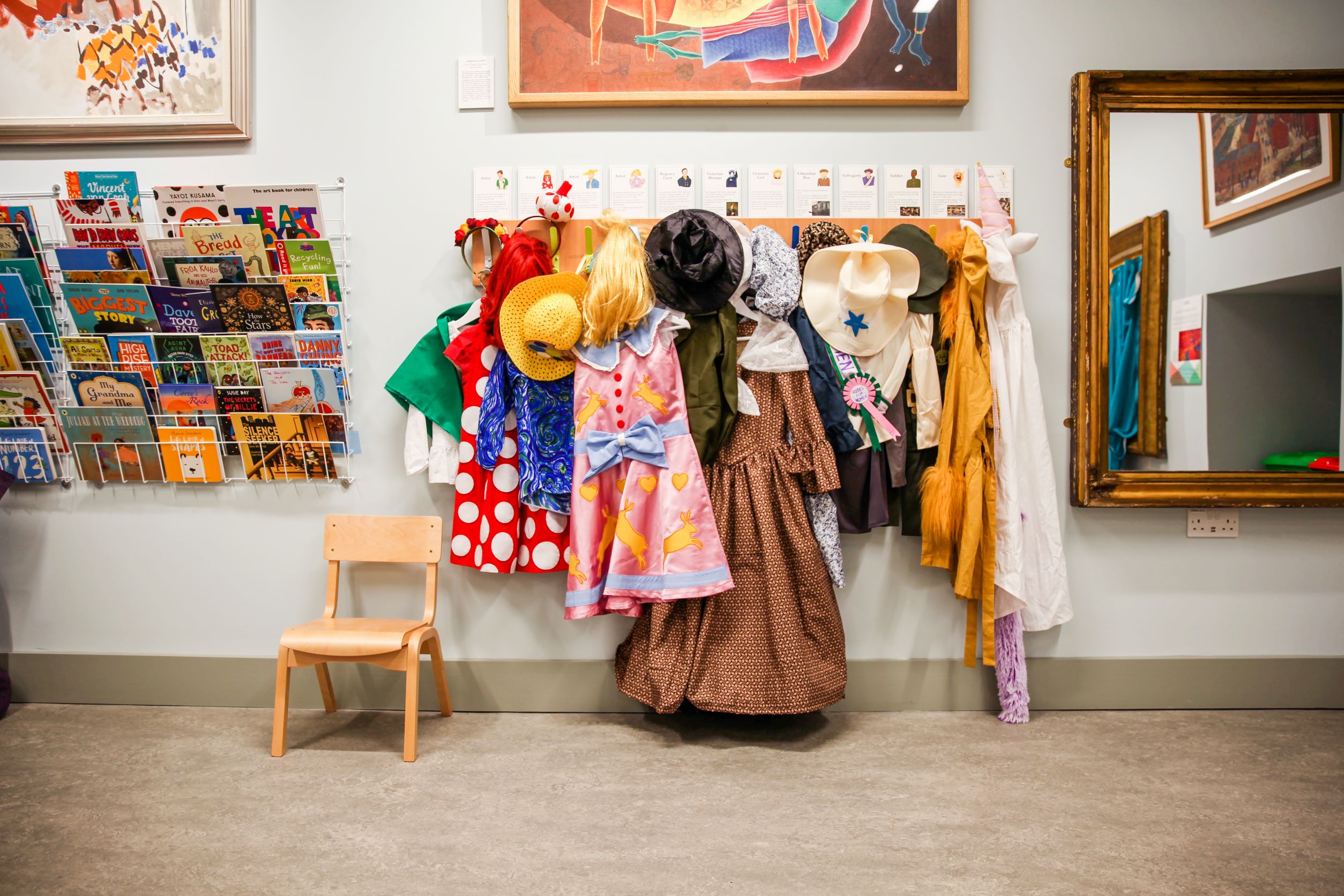 A selection of books, costumes and a small chair in the RWA Family Activity Space 