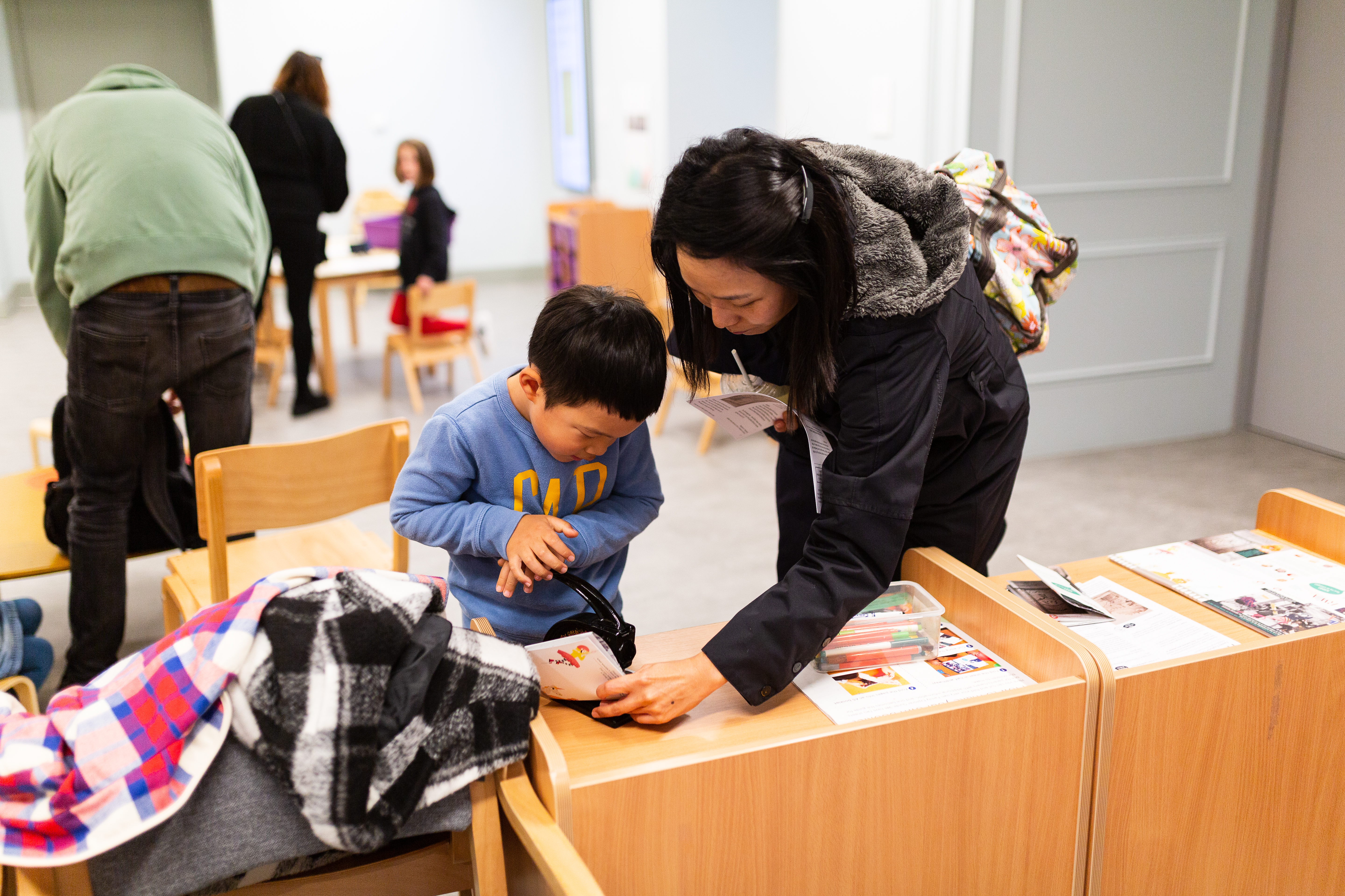 A little boy and mum using an embosser in the Family Activity Space 