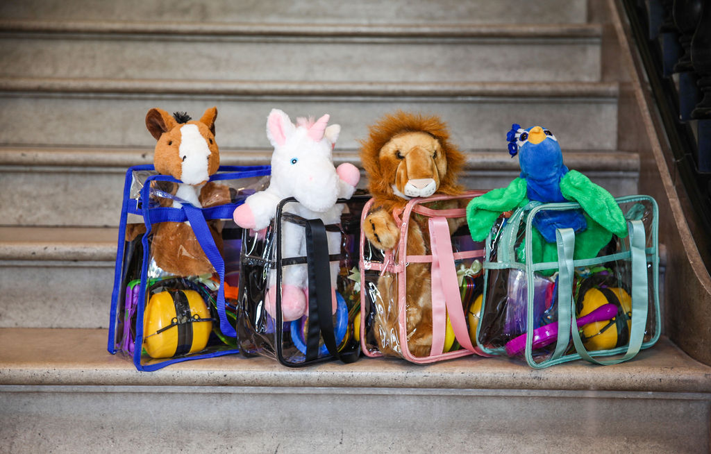 Sensory bags lined up on the RWA stairs, each bag has a character relevant to RWA history including a unicorn, peacock and lion 