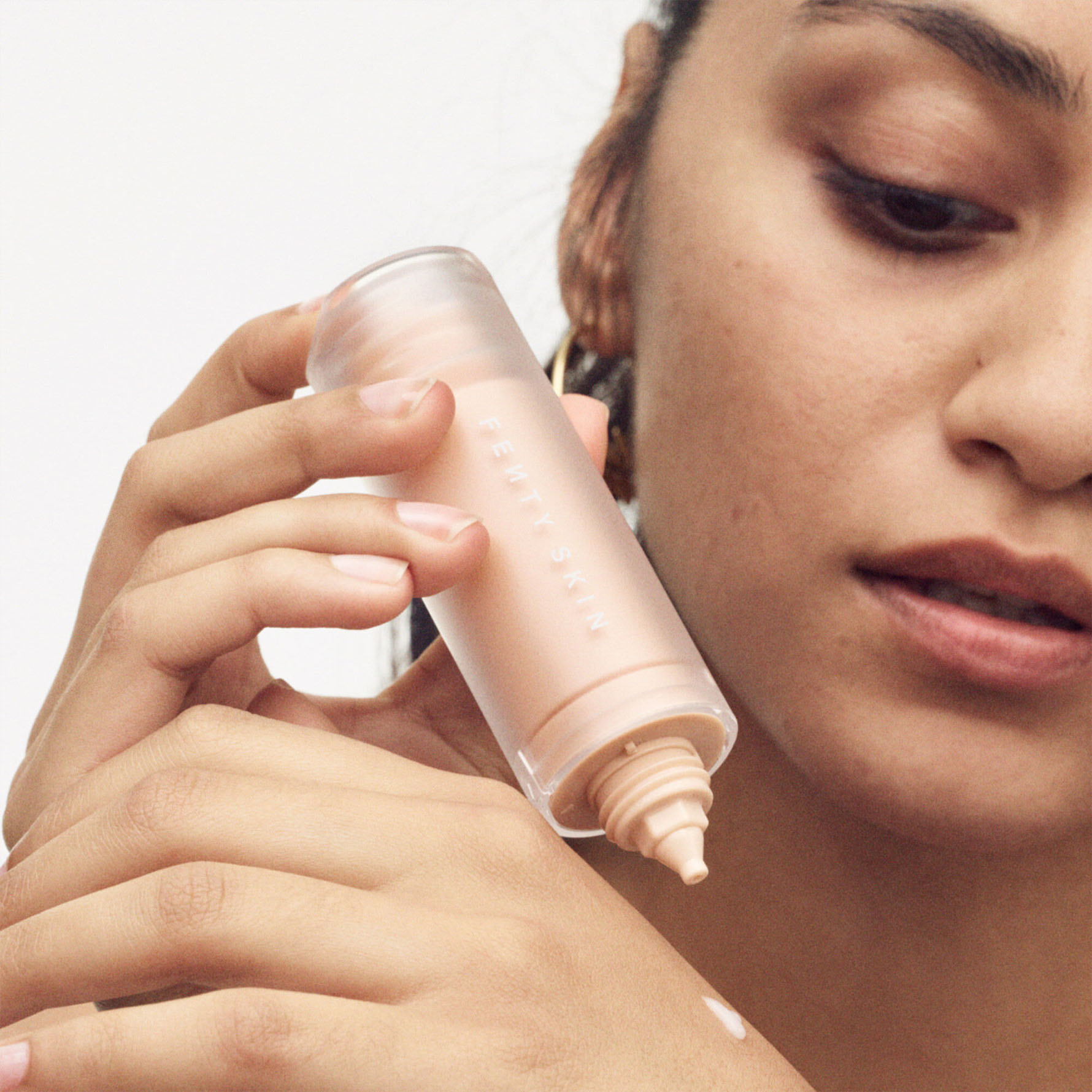 Model dispensing watch ya tone onto back of her hand.