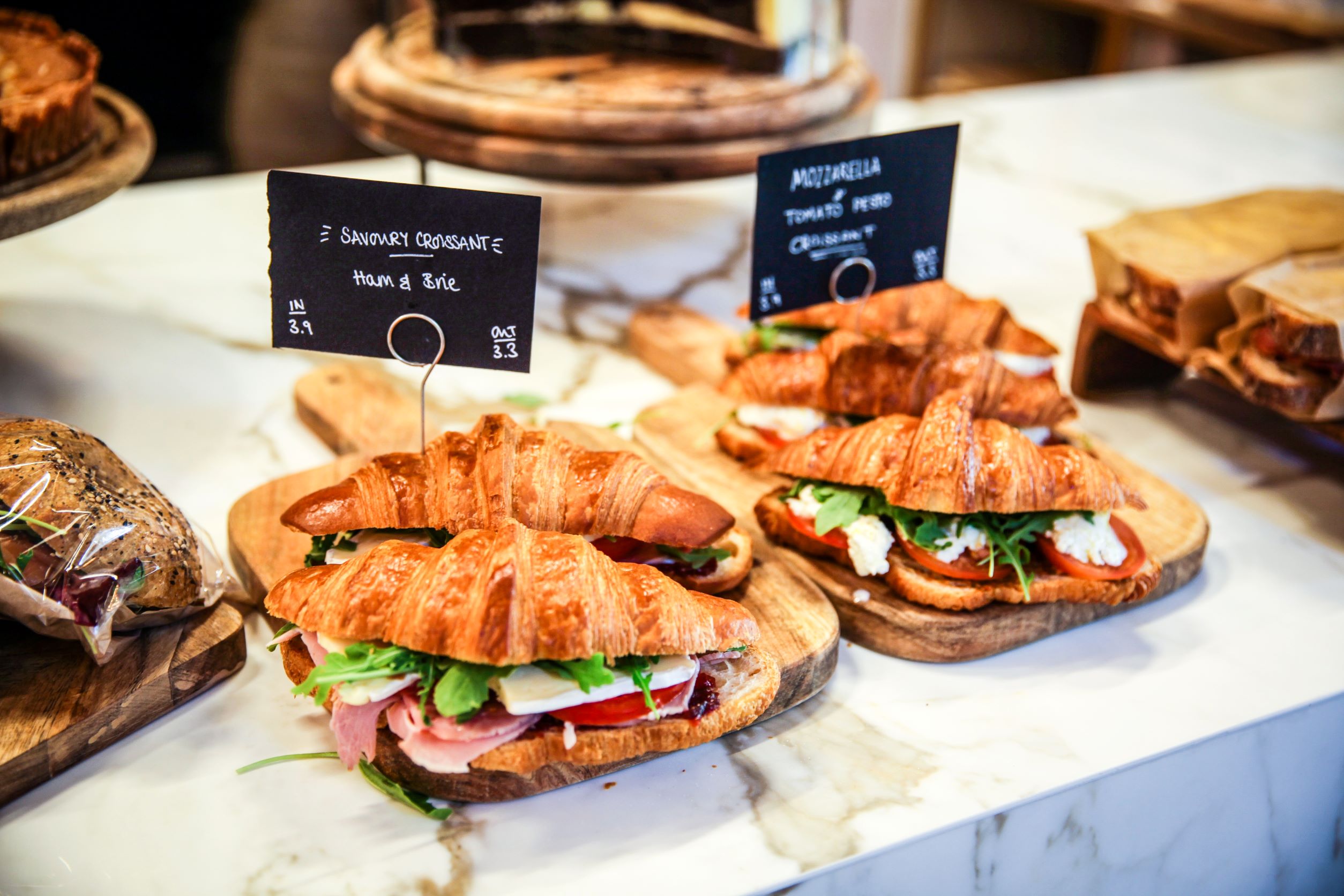 Filled croissants on display on a marble counter top 