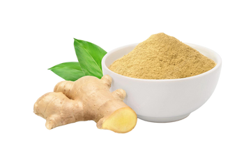 ginger powder in a bowl with raw ginger