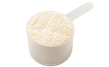 100% Grass-Fed Whole Milk Powder in a plastic scoop
