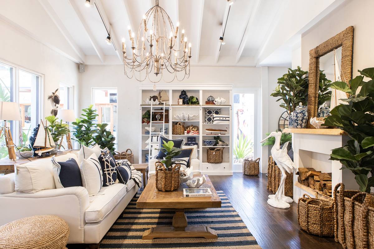 A classic Hampton styled living room featuring blue cushions on a white lounge with striped jute rug at the Alfresco Emporium Bundall store.