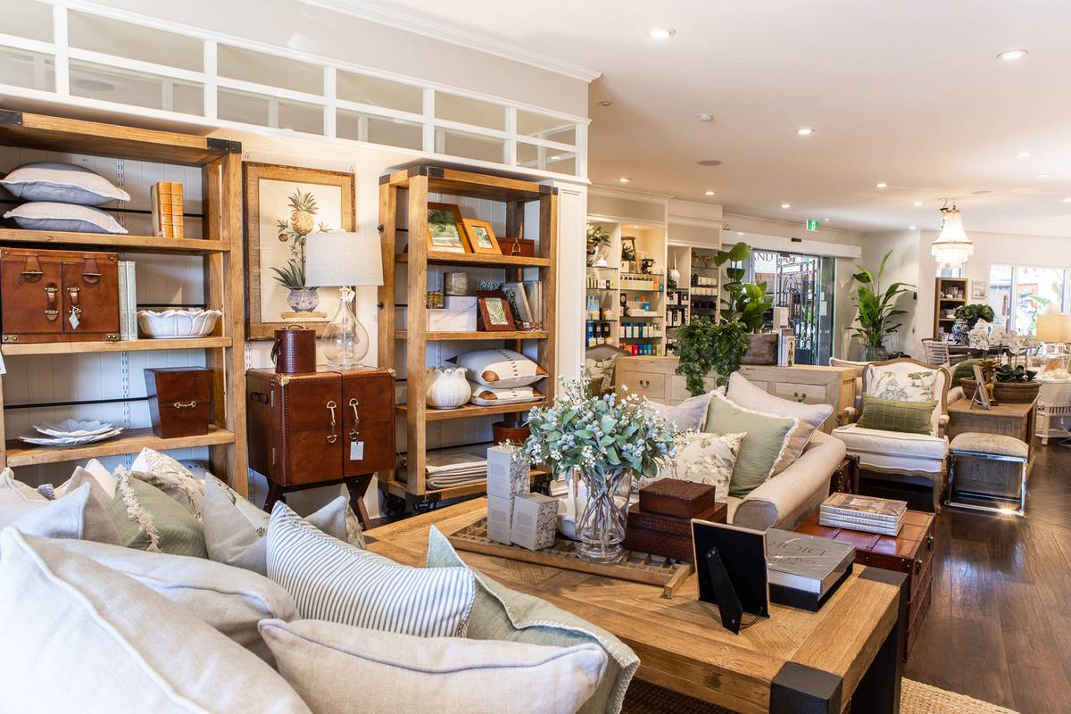 A wide view of the inside of our Bundall store showing a comfortable lounge with raw elm timber coffee table and matching bookcases.